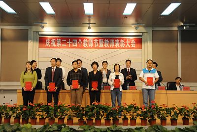 图为校领导为“师德标兵”颁发奖励证书